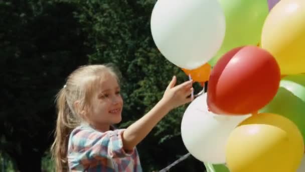 Primer plano retrato preescolar chica saludando de la mano y jugando con globos — Vídeos de Stock