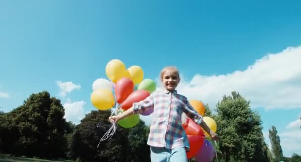 Gelukkig meisje portret spinnen met ballonnen tegen de hemel — Stockvideo