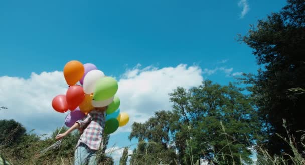 Niña preescolar girando con globos en el parque — Vídeos de Stock