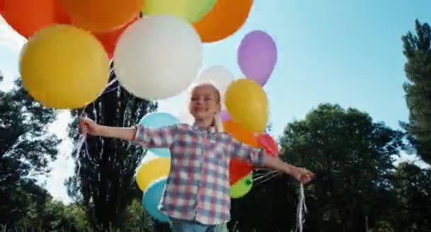 Chica girando con globos y mirando a la cámara — Vídeo de stock