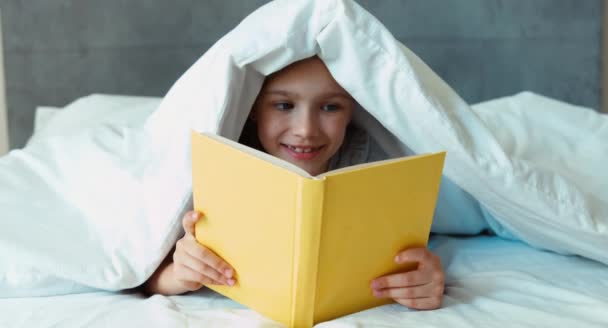 Ragazza bambino lettura libro sotto la coperta e ridere — Video Stock