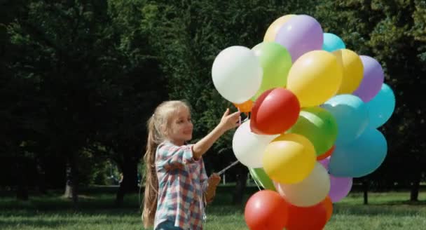 Niña preescolar saludando mano y jugando con globos — Vídeos de Stock