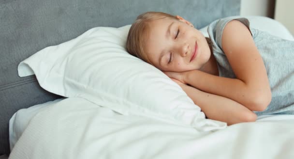 Κορίτσι πορτρέτο closeup στον ύπνο σε ένα κρεβάτι και χαμογελαστός — Αρχείο Βίντεο