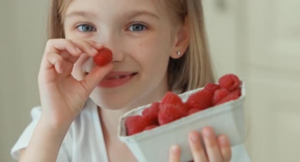 Close up retrato menina comer framboesas e rindo da câmera — Vídeo de Stock