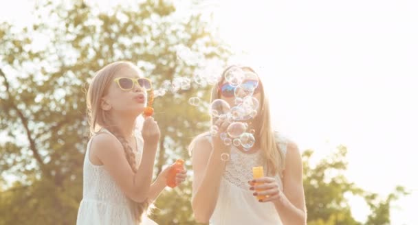 La famille souffle des bulles au coucher du soleil — Video