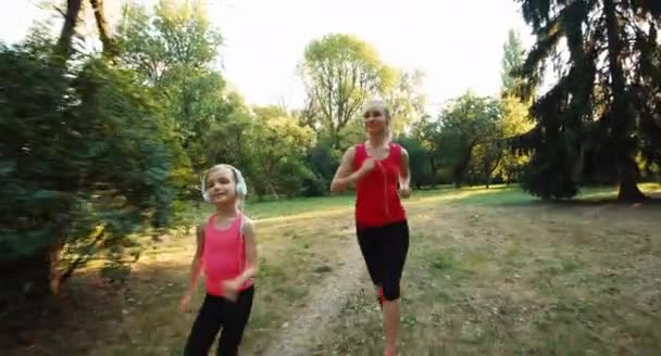 Atleta família mãe correndo contra a luz solar — Vídeo de Stock