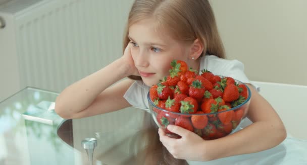 Girl hugging big plate of strawberries and laughing at camera. Top view — Stock Video