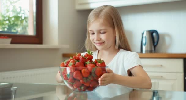 Menina admirando um grande prato de morangos e olhando para a câmera. Polegares para cima. Está bem. — Vídeo de Stock
