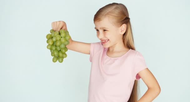 Дівчина тримає виноград і сміється з камери. Палець вгору. гаразд — стокове відео
