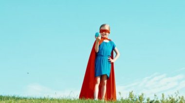 Güçlü süper kahraman kız çocuğu dünyaya mavi gökyüzüne karşı korur. Yaşasın. Tamam