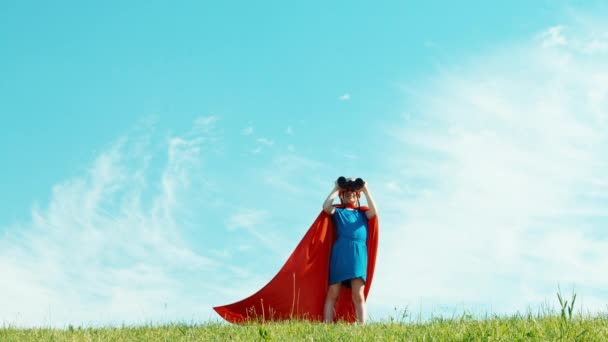 Superheld met verrekijker meisje kind 7-8 jaar oude beschermt de wereld tegen de blauwe hemel — Stockvideo