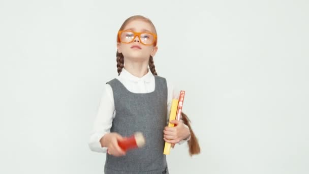 Angry teacher on white background. Girl with glasses holding books and a big pencil — Stock Video