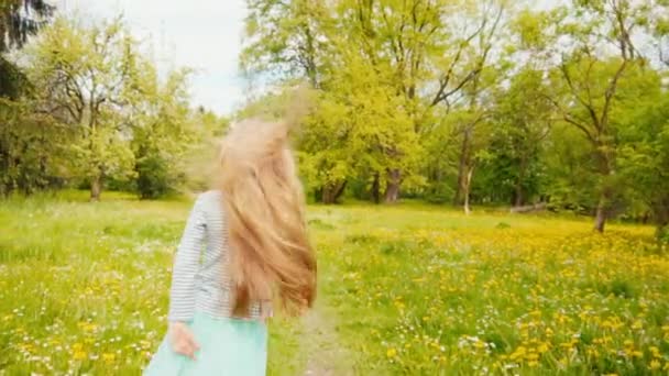 Retrato de niña de 7-8 años en falda azul girando en el parque en la primavera. Cámara lenta desde Sony A6300 — Vídeos de Stock