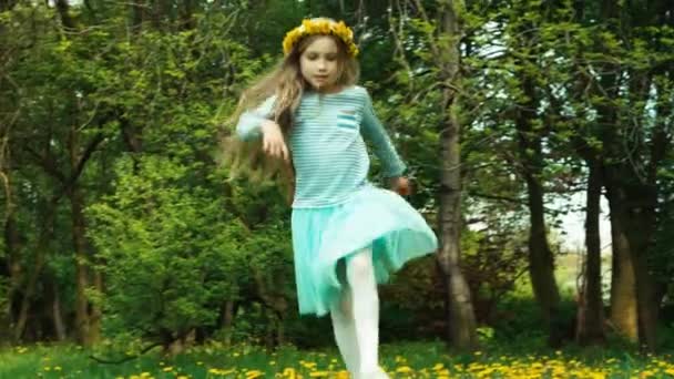 Meisje 7-8 jaar oude dansen op de glade van paardebloemen — Stockvideo