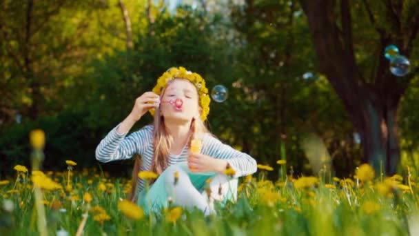 Ragazza carina 7-8 anni soffia bolle di sapone nel parco. Rallentatore Sony A6300 — Video Stock