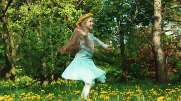 Girl 7-8 years old spinning on the glade of dandelions in the soap bubbles — Stock Video