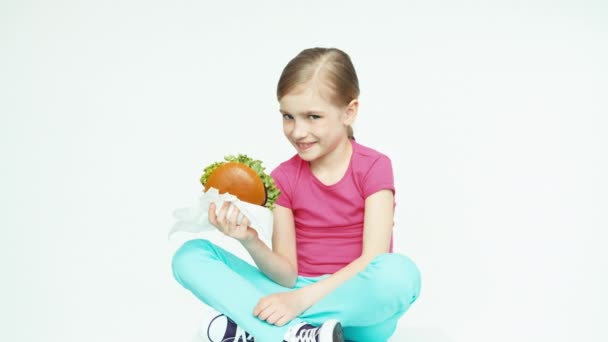 Дівчинка 7-8 років тримає бургер. Палець вгору. гаразд — стокове відео