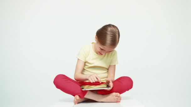 Cute girl 7-8 years old using tablet pc on white background. Thumb up. Ok — Stock Video