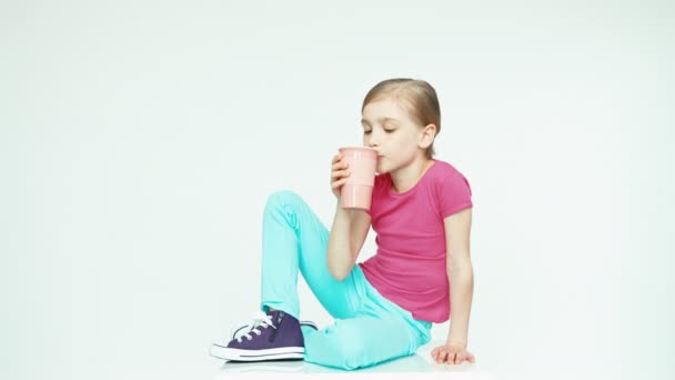 Niña 7-8 años bebiendo té de la taza — Vídeo de stock