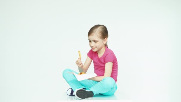 Fille mignonne enfant 7-8 ans manger des pommes de terre sur le fond blanc — Video