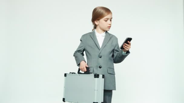 Biznes dziewczynka z przypadku i telefon komórkowy na białym tle — Wideo stockowe