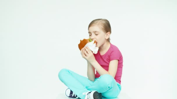 Menina 7-8 anos comer hambúrguer — Vídeo de Stock