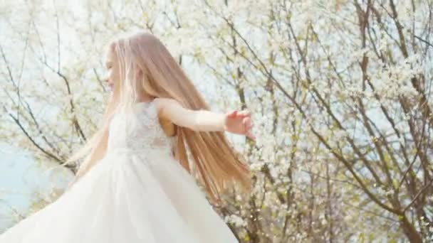 Princesa retrato girando em um vestido branco em um vestido em um fundo de árvores florescentes. Sony A6300 — Vídeo de Stock