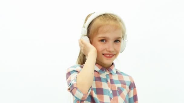 Closeup portrait girl listening music and dancing on the white background — Stockvideo