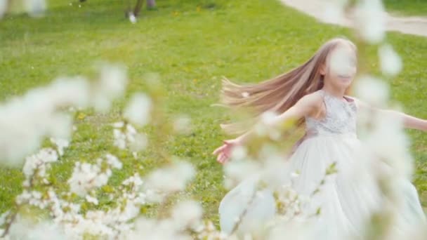 Chica feliz girando en un vestido blanco en la hierba. Sony A6300 de cámara lenta — Vídeo de stock