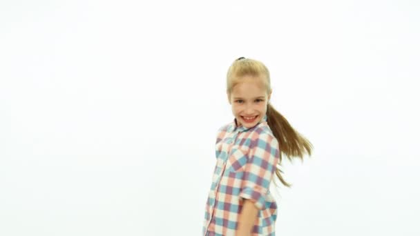 Смеющаяся девушка поворачивается к камере на белом фоне — стоковое видео