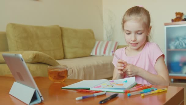 Niedliches Mädchen 7 Jahre alt Zeichnung in einem Notizbuch und Tee trinken — Stockvideo