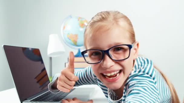 Extreme Nahaufnahme Porträt Kind Mädchen 7-8 Jahre alt etwas auf ihrem Laptop tippt und lacht in die Kamera. Daumen hoch. ok — Stockvideo