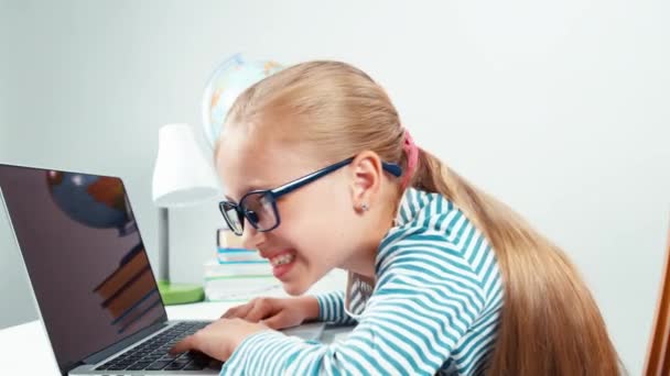 Loca chica usando el ordenador portátil y riendo de la cámara aislada en blanco. Primer plano retrato — Vídeo de stock