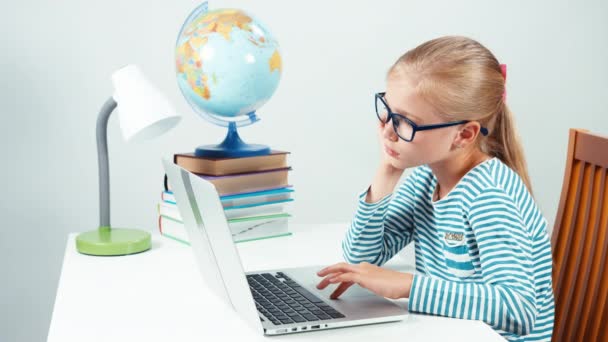 Retrato menina triste em óculos usando laptop e olhando para a câmera. Criança isolada em branco — Vídeo de Stock