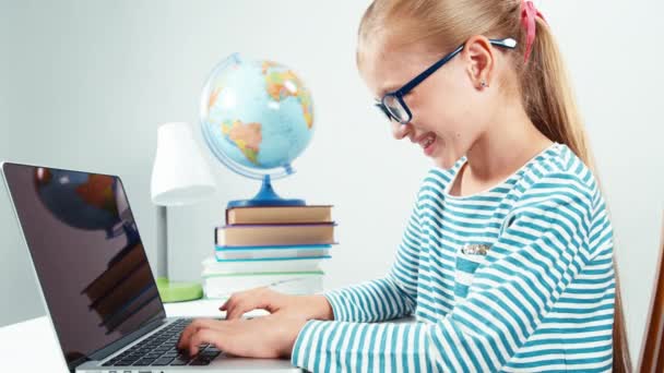 Close up portrait child 7-8 years old something typing on her laptop and laughing at camera — Stock Video