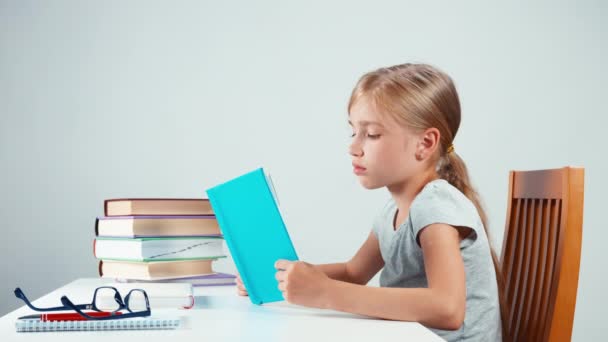 Sad schoolgirl student with book on her head — Αρχείο Βίντεο
