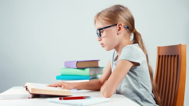 Portré profil diák lány gyermek 7-8 év valami írás a notebook az asztalára, és látszó-on fényképezőgép — Stock videók