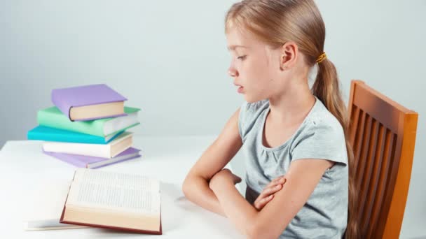 Portret profiel student meisje kind 7-8 jaar lezen boek en lachend op camera met tanden. Bovenaanzicht. Geïsoleerd — Stockvideo