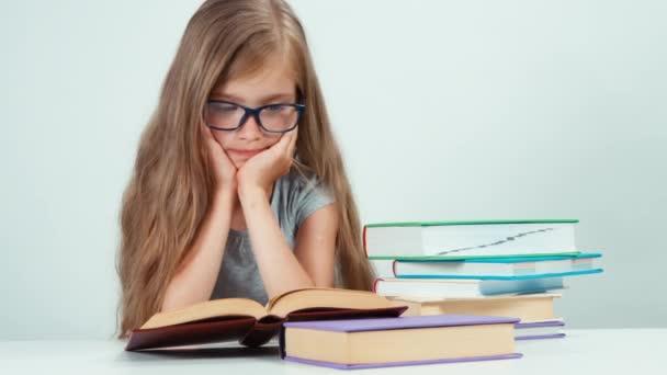 Close up portrait happy girl with long blond hair 7-8 years in glasses reading book — ストック動画