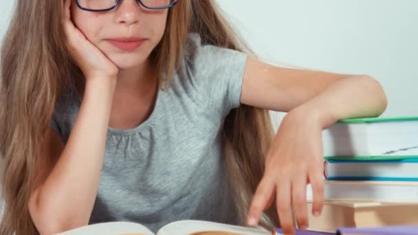 Extremo primer plano retrato linda estudiante chica con el pelo largo y rubio 7-8 años en gafas libro de lectura y sonriendo. Panorama — Vídeos de Stock