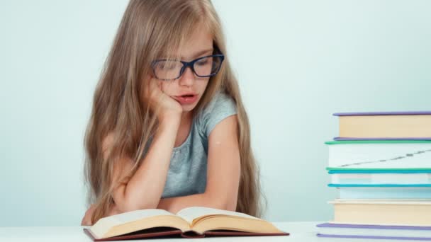 Retrato lindo estudiante chica con pelo largo 7-8 años en gafas libro de lectura — Vídeos de Stock