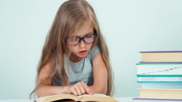 Közelről portré aranyos diák lány 7-8 év-könyv olvasó szemüveg — Stock videók