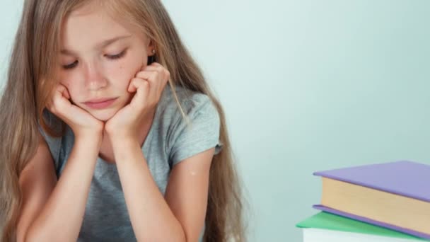 Close-up portret meisje 7-8 jaar oud boek lezen en lachend met tanden op camera. Pannen — Stockvideo