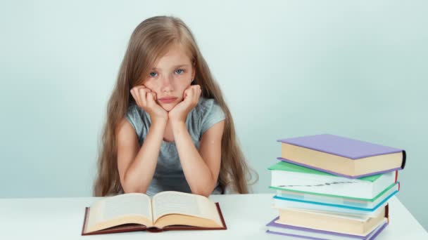 Üzgün kız öğrenci 7-8 yaş arası okuma kitabı tablo ve kamera beyaz arka plan üzerinde seyir — Stok video