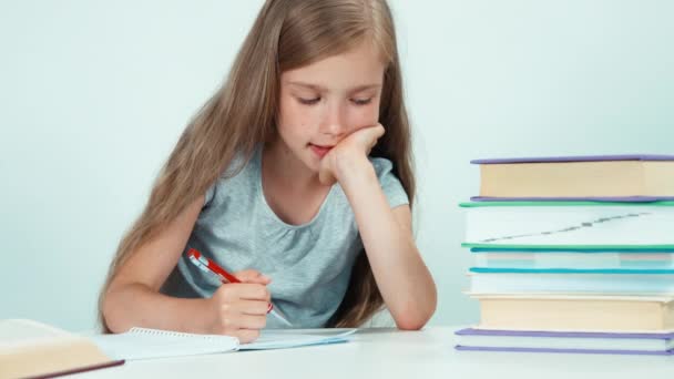 Girl something writing in her notebook. Isolated on white — Stock video