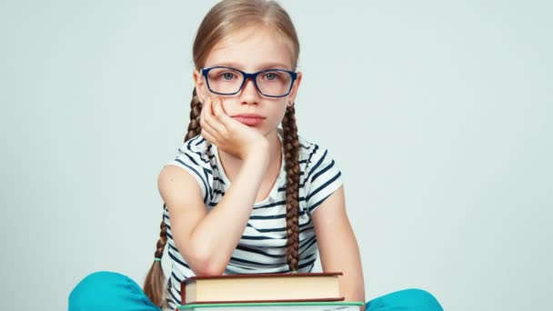 Schoolmeisje in glazen oog op camera en lacht knipogend — Stockvideo