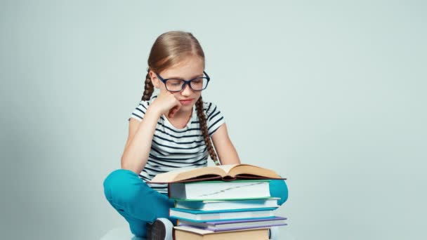 Schoolgirl reading a book and stretching smiling at camera sitting on the floor — Αρχείο Βίντεο