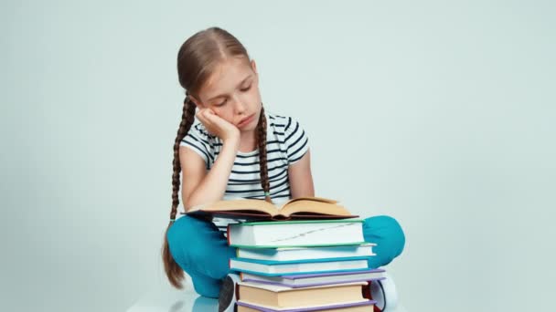 Close up portrait sad girl reading book and looking at camera on white — Stockvideo