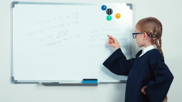 Very smart nerd with glasses standing near whiteboard smiling at the camera — Stock video