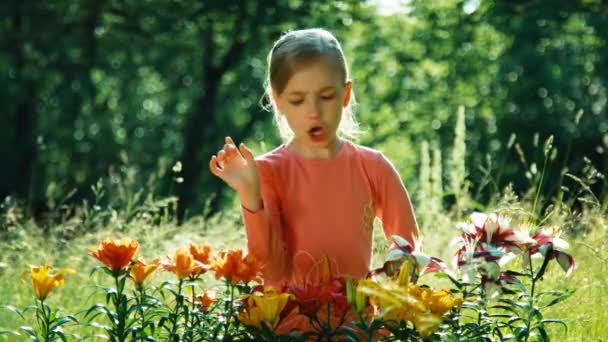 Portret meisje 7-8 jaar met bloemen in de tuin — Stockvideo